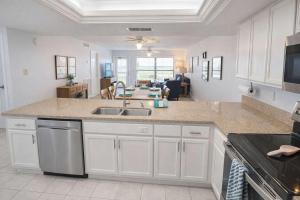 a kitchen with a sink and a living room at Resort like super heated pool & direct beach front in South Padre Island