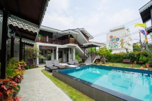 a house with a swimming pool in front of a house at Cozy Lanna Hotel in Chiang Mai