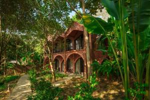 a brick building in the middle of a forest at Maida Lodge in Hòa Bình