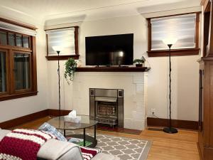 a living room with a fireplace with a flat screen tv at Restly an Elegant Home by Whyte Ave in Edmonton
