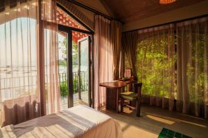 a bedroom with a bed and a desk and a window at Maida Lodge in Hòa Bình +172 photos