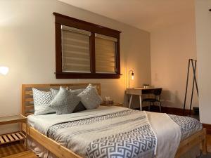 a bedroom with a bed with a window and a table at Restly an Elegant Home by Whyte Ave in Edmonton +28 photos