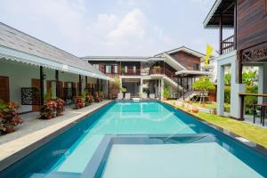 a swimming pool in front of a house at Cozy Lanna Hotel in Chiang Mai