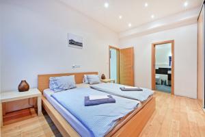 una camera da letto con un grande letto con lenzuola blu di Family Apartments a Praga