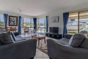 a living room with two couches and a tv at Holiday on the Water in Sussex Inlet