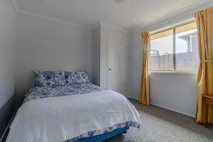 a bedroom with a bed and a window at Holiday on the Water in Sussex Inlet