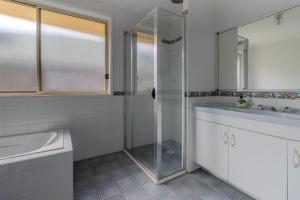a bathroom with a shower and a sink at Holiday on the Water in Sussex Inlet +17 photos