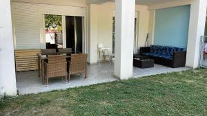 a patio with chairs and a couch on a house at Lelle Riviera in Balatonlelle