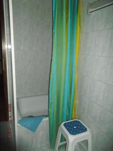 uma casa de banho com uma cortina de chuveiro e um banco em Ferienhaushälfte Lütow em Lütow