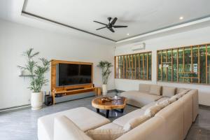 a living room with a couch and a tv at Luxury 5BR Villa with Rooftop BBQ Pool 500M to Beach in Canggu