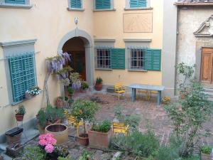 a courtyard of a house with a table and some plants at B&B Borgo Ponte dell'Asse in Florence