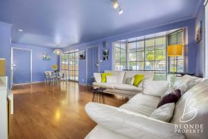 a living room with blue walls and a white couch at La Maison Bleue in Ballarat