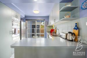 a kitchen with a white counter top and blue cabinets at La Maison Bleue in Ballarat