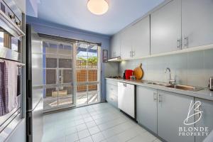 a kitchen with white cabinets and a large window at La Maison Bleue in Ballarat +11 photos