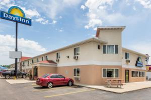 um hotel com um carro vermelho estacionado num parque de estacionamento em Days Inn by Wyndham Sioux City em Sioux City