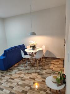 a living room with a table and a blue couch at Haurea House in São Luís