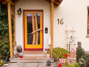 una porta arancione anteriore di una casa con un numero di Haus Wollmeister a Bad Liebenzell