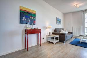 ein Wohnzimmer mit einem Sofa und einem Tisch in der Unterkunft Residenz am Balmer See - BS 02 mit Wellnessbereich in Balm