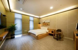 ein Hotelzimmer mit Bett, Schreibtisch und Stuhl in der Unterkunft Naju Holius Hotel in Naju
