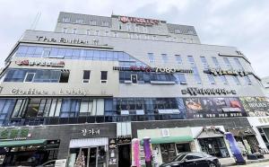 ein Gebäude in einer Straße mit einem davor geparkten Auto in der Unterkunft Naju Holius Hotel in Naju