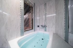 a bathroom with a bath tub with a mirror at Hotel CARA 大人専用Adult only hotel in Tokyo