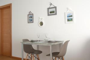 a table with chairs and wine glasses on it at Quinta das Pedreiras in Pico da Pedra
