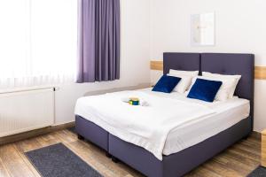 a bedroom with a large bed with blue pillows at Apartments R Sport boutique with free Parking in Sarajevo +11 photos