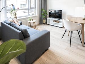 a living room with a couch and a table at Spacious Family Stay Eindhoven, Garden & Kitchen in Eindhoven