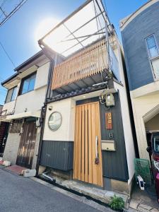 a house with a wooden door with a balcony at 楽途居 in Osaka