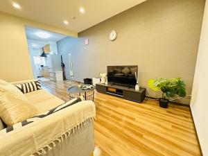 a living room with a couch and a flat screen tv at 楽途居 in Osaka