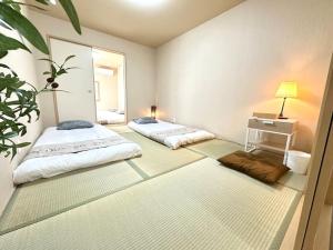 a room with two beds and a table and a mirror at 楽途居 in Osaka