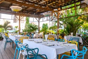 a restaurant with white tables and blue chairs at Naiya Sea Resort in Sihanoukville