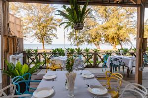 a table with white plates and chairs on a patio at Naiya Sea Resort in Sihanoukville