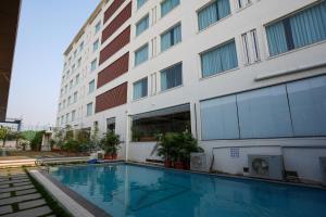 a hotel with a swimming pool in front of a building at Town Square Suites in Hyderabad