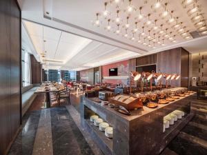 a buffet line in a hotel lobby with a restaurant at Maison New Century Ninghai Railway Station in Ninghai