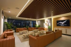 a lobby with couches and tables and a tv at Town Square Suites in Hyderabad