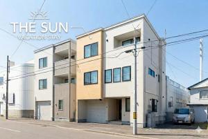 a building on a street with the sun vacationominiumstay sign at THE SUN in Sapporo