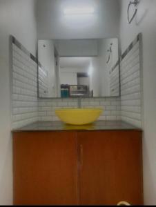 a bathroom with a yellow sink and a mirror at PERIYAR Paradize Inn,Kumily in Thekkady
