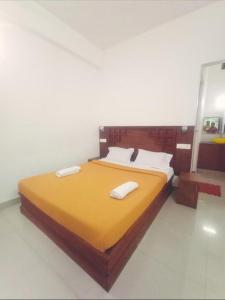 a bedroom with a bed with two towels on it at PERIYAR Paradize Inn,Kumily in Thekkady +5 photos