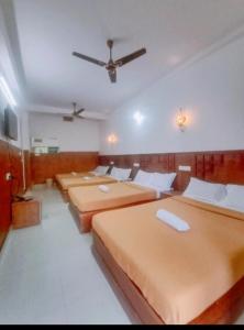 a row of beds in a room with a ceiling at PERIYAR Paradize Inn,Kumily in Thekkady