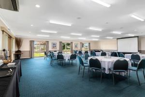 a conference room with tables and chairs and a screen at Quality Inn Carriage House in Wagga Wagga +57 photos