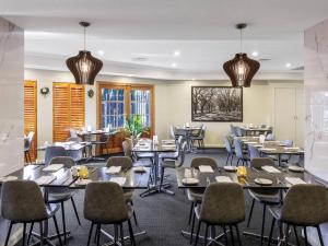 a restaurant with tables and chairs in a room at Quality Hotel Melbourne Airport in Melbourne