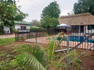 a fence with a pool in front of a house at Buffalo Bob Lodge & Tours in Livingstone