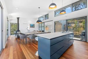 a kitchen and dining room with a dining table at Architectural Beachfront Escape Yowani House in Tomakin