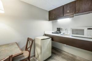 a small kitchen with a refrigerator and a sink at Clarion Hotel Jackson Northwest in Jackson