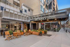 a patio with chairs and tables in front of a hotel at The Quincy, an Ascend Collection Hotel in Washington, D.C.