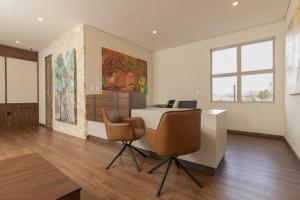 ein Büro mit einem Schreibtisch und zwei Stühlen in einem Raum in der Unterkunft Hotel Santolivo by Lumina in Parras de la Fuente