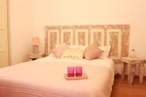 a bedroom with a bed with two cups on it at Lanui Guest House in Sintra