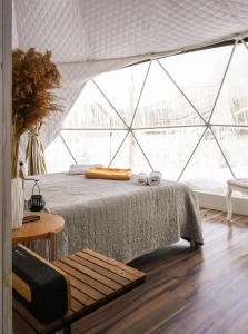 a bedroom with a bed with a large window at Eco Dom Tent in Vedi