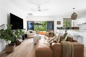 a living room with a couch and a kitchen at Noosa International Resort in Noosa Heads